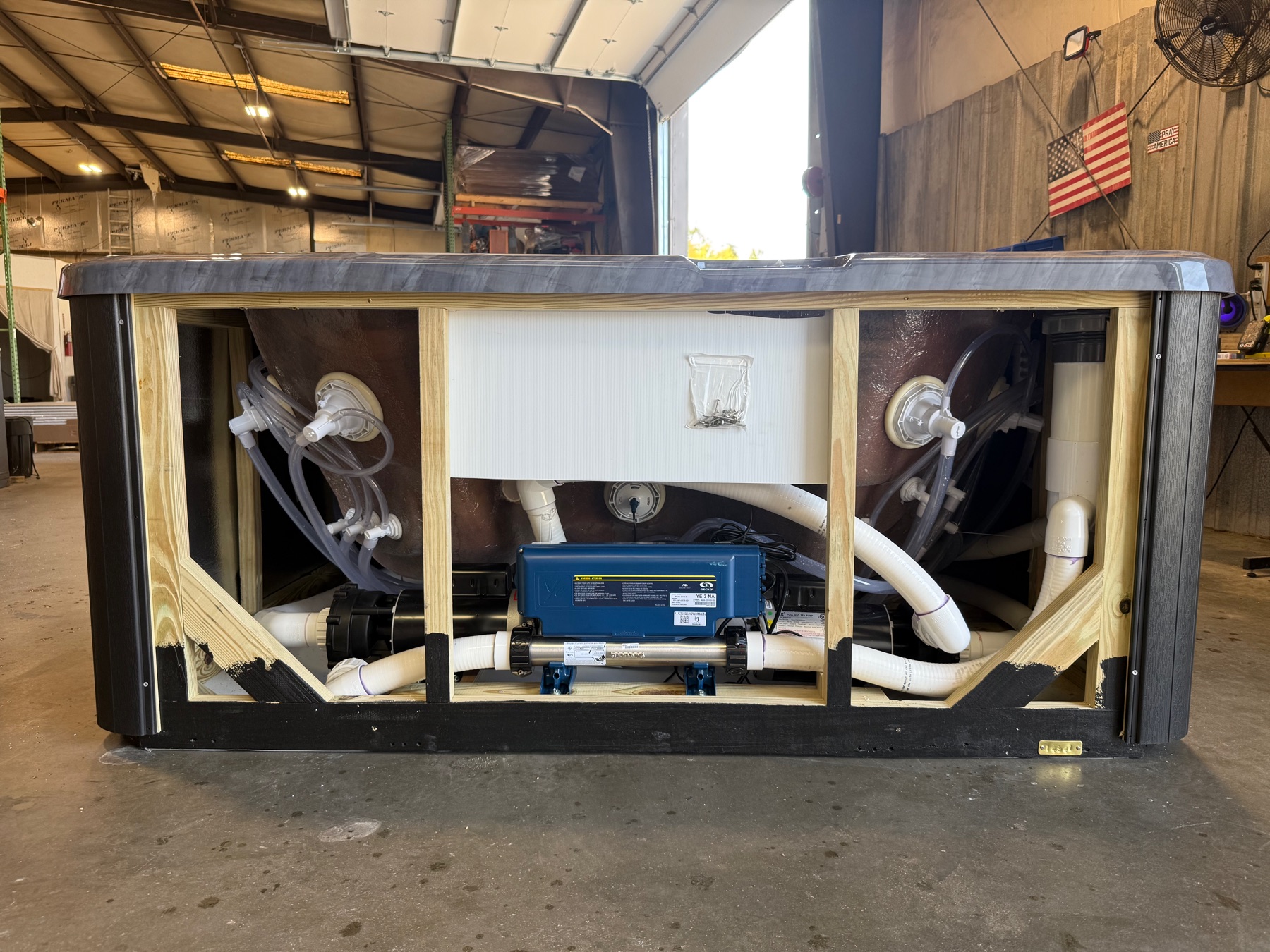 Open Futura Spa equipment bay showing frame, pumps, plumbing, and controls